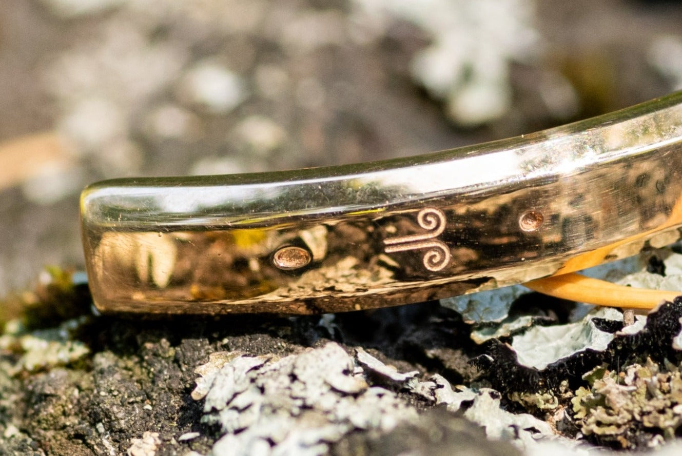 Detail shot of a Counterbalance bracelet project engraving for wind energy climate action carbon offsets.