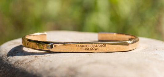 A 15 ton bronze Counterbalance bracelet sitting on a smooth river stone on the clark fork river in Missoula, Montana